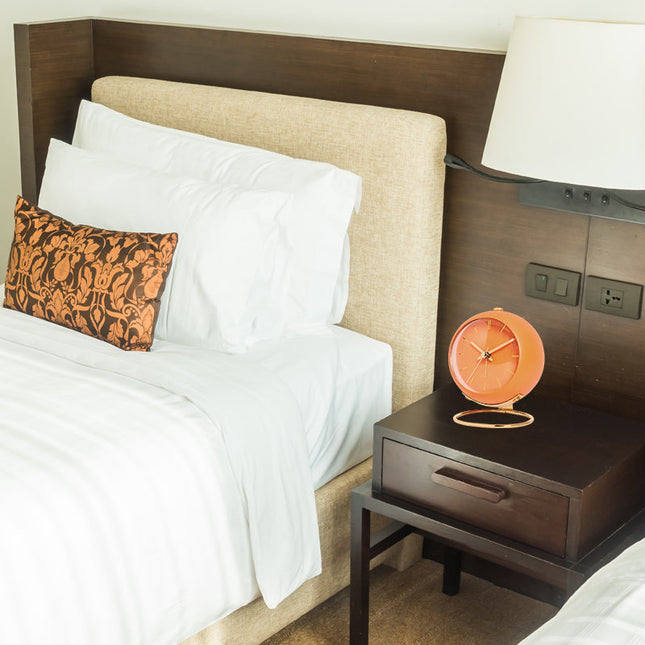 Oransje vintage vekkerklokke med gullstativ